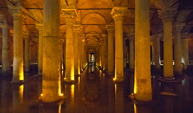 a long hallway with columns and lights in it